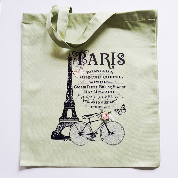 hellgrüne Stofftasche mit der Beschriftung "Paris", verschiedener frz. Ausdrücke, Eiffelturm und Fahrrad.