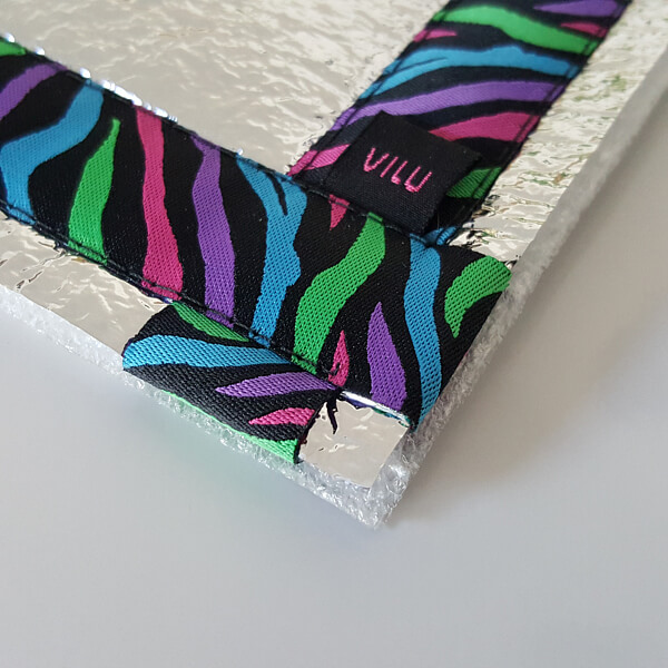 Sitzkissen-Ausschnitt Ecke mit VILU-Logo mit Ripsbanddesign Zebrafell bunt