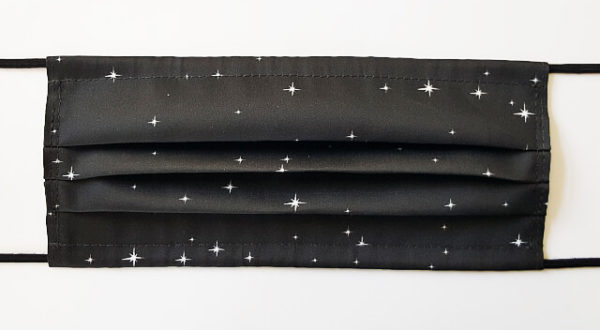 Schwarze Mund-Nase-Maske in Kuvertform mit locker verteilten weiß blitzenden Sternen.