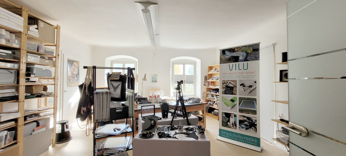 Informationen zur Marke VILU 1 VILU-Atelier mit Regalen, Produkten auf Tischen und Ständer, Roll-Up